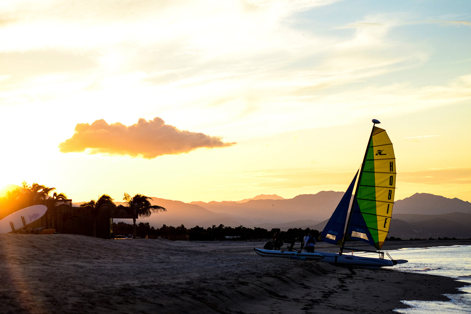 Beach at sunset with sailboat